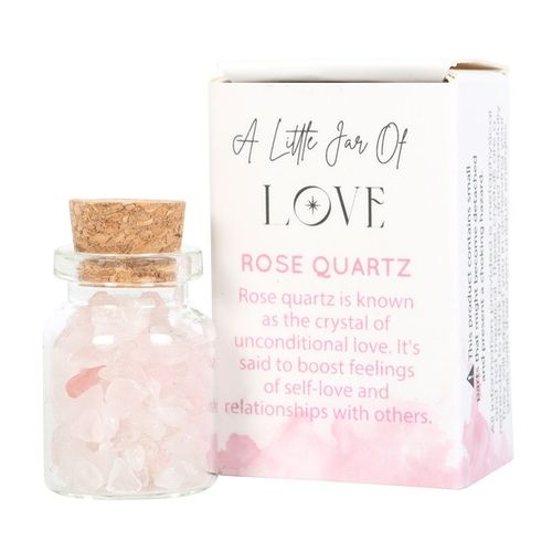 A small glass jar filled with Rose Quartz crystal chips, sealed with a cork lid, and displayed next to a matchbox-style package labeled "A Little Jar of Love." This healing crystal promotes self-love, emotional healing, and heart chakra balance. A perfect spiritual gift for mindfulness and manifestation.