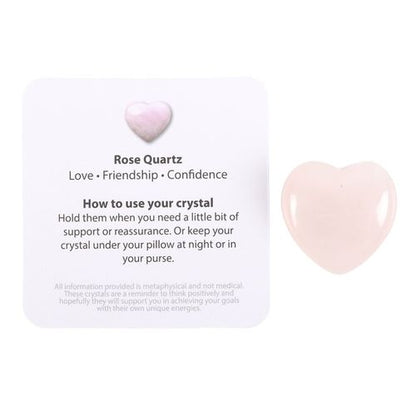 A polished Rose Quartz Crystal Heart displayed with an informational card detailing its benefits for love, friendship, and confidence. The card provides guidance on how to use the crystal for emotional support, reassurance, and heart chakra healing. A perfect gift for self-love and spiritual well-being.