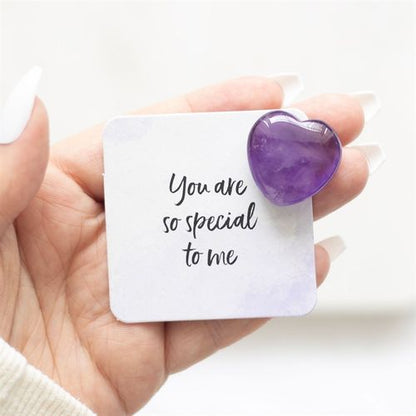 A hand holding a polished Amethyst Crystal Heart alongside a sentiment card that reads "You Are So Special to Me." This healing crystal promotes emotional balance, stress relief, and spiritual clarity, making it a meaningful gift for mindfulness, meditation, and self-care.